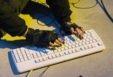 HubSpot-vs-wordpress_Hacker-wearing-cutoff-gloves-typing