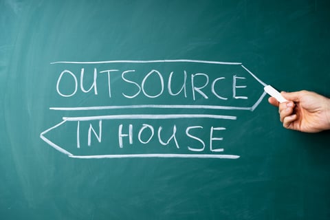 outsourcing b2b digital marketing - 'outsourcing vs. in house' written on chalkboard